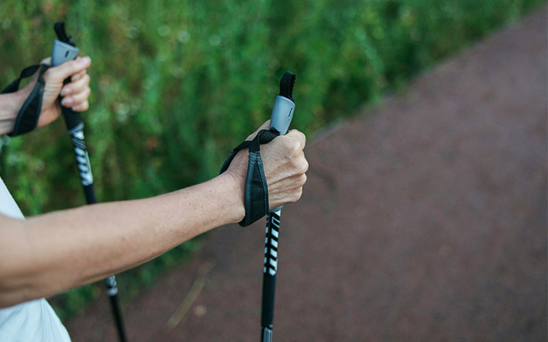 Nordic-Walking-mit-Prothese Auf dem Bild ist eine Person mit Nordic-Walking-Stöcken zu sehen.