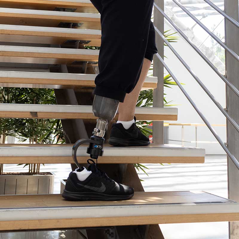 Bild von einer Anwenderin, die mit dem AllPro XTS eine Treppe hochsteigt.